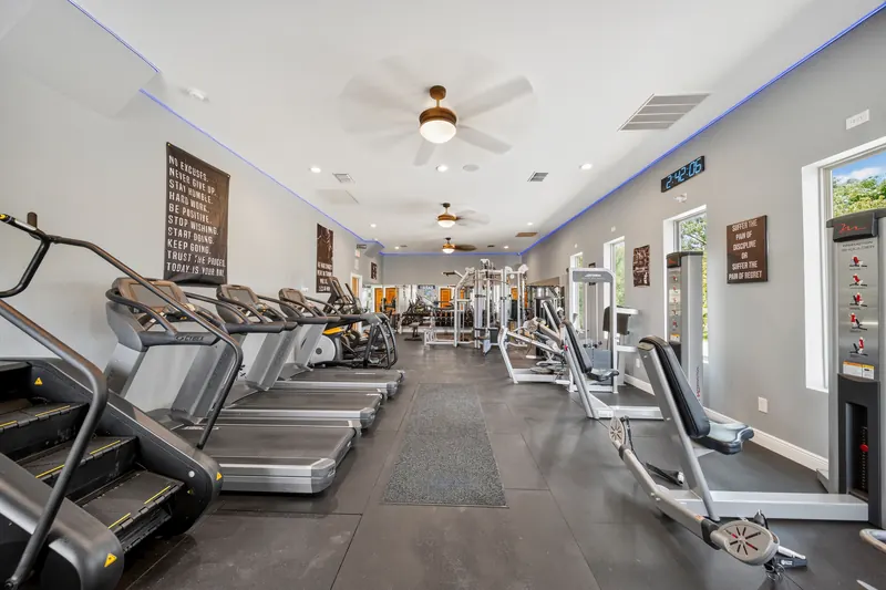 The main floor at Comfort Fitt, treadmills along the left wall and strength machines toward the back.